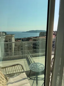 Furnished terrace with a view of the sea and surrounding buildings. - image 7