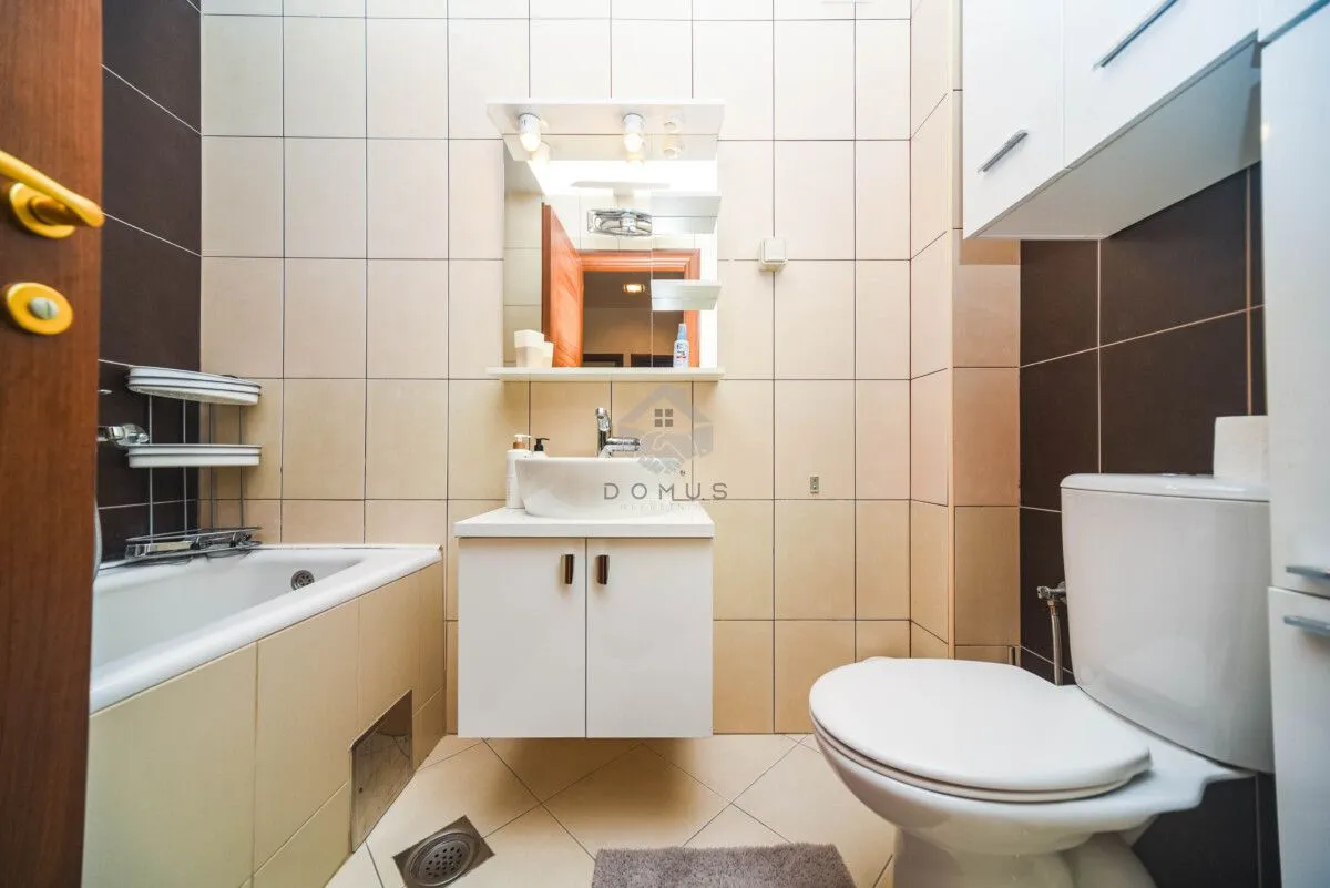 Bathroom equipped with a washbasin, vanity unit, bathtub, and toilet.
