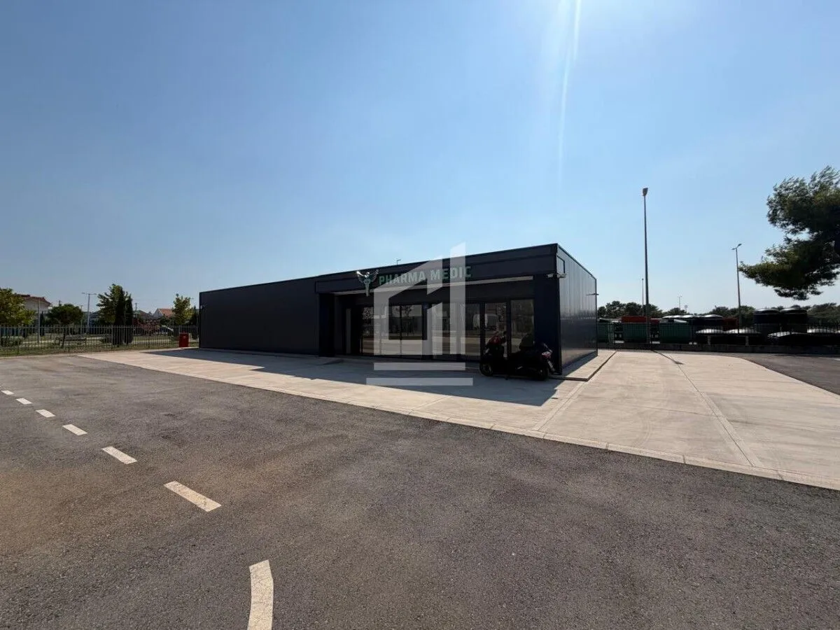 Exterior view of a modern commercial building with an adjacent parking lot.