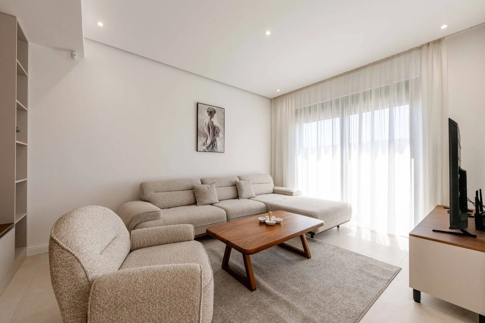 Bright living room with a sofa, armchair and wooden coffee table.