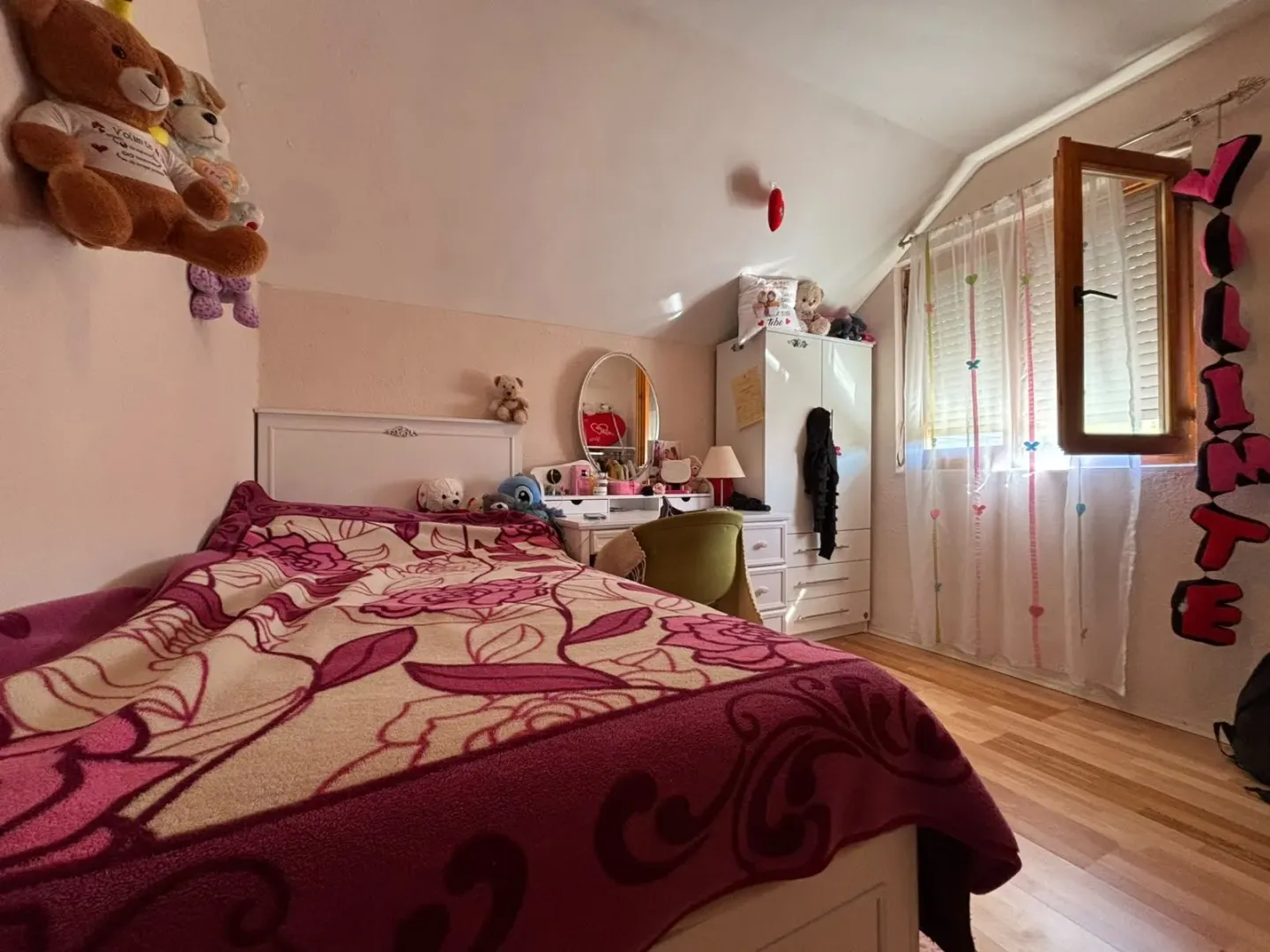 Children's bedroom with a bed, wardrobe, desk, and a window.