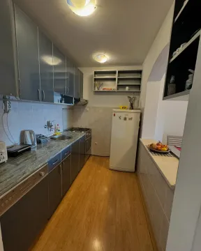 Manja opremljena kuhinja sa drvenim podom i bijelim frižiderom. - image 3