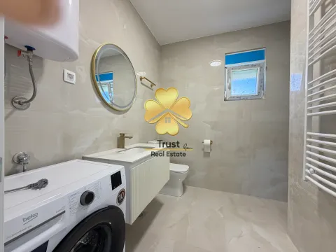 Modernly equipped bathroom with a washbasin, mirror, and washing machine. - image 9