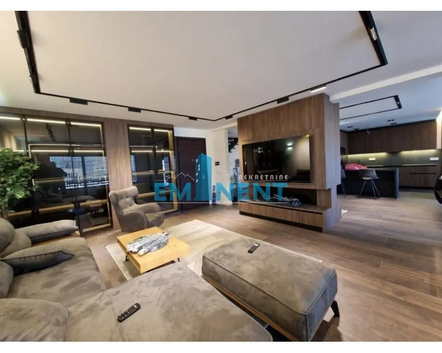 Spacious living room connected to the kitchen, equipped with modern furniture and recessed lighting.