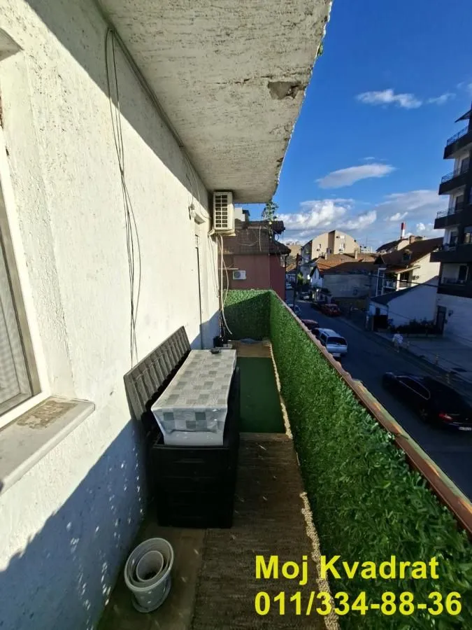 Long balcony with artificial grass and a street view.