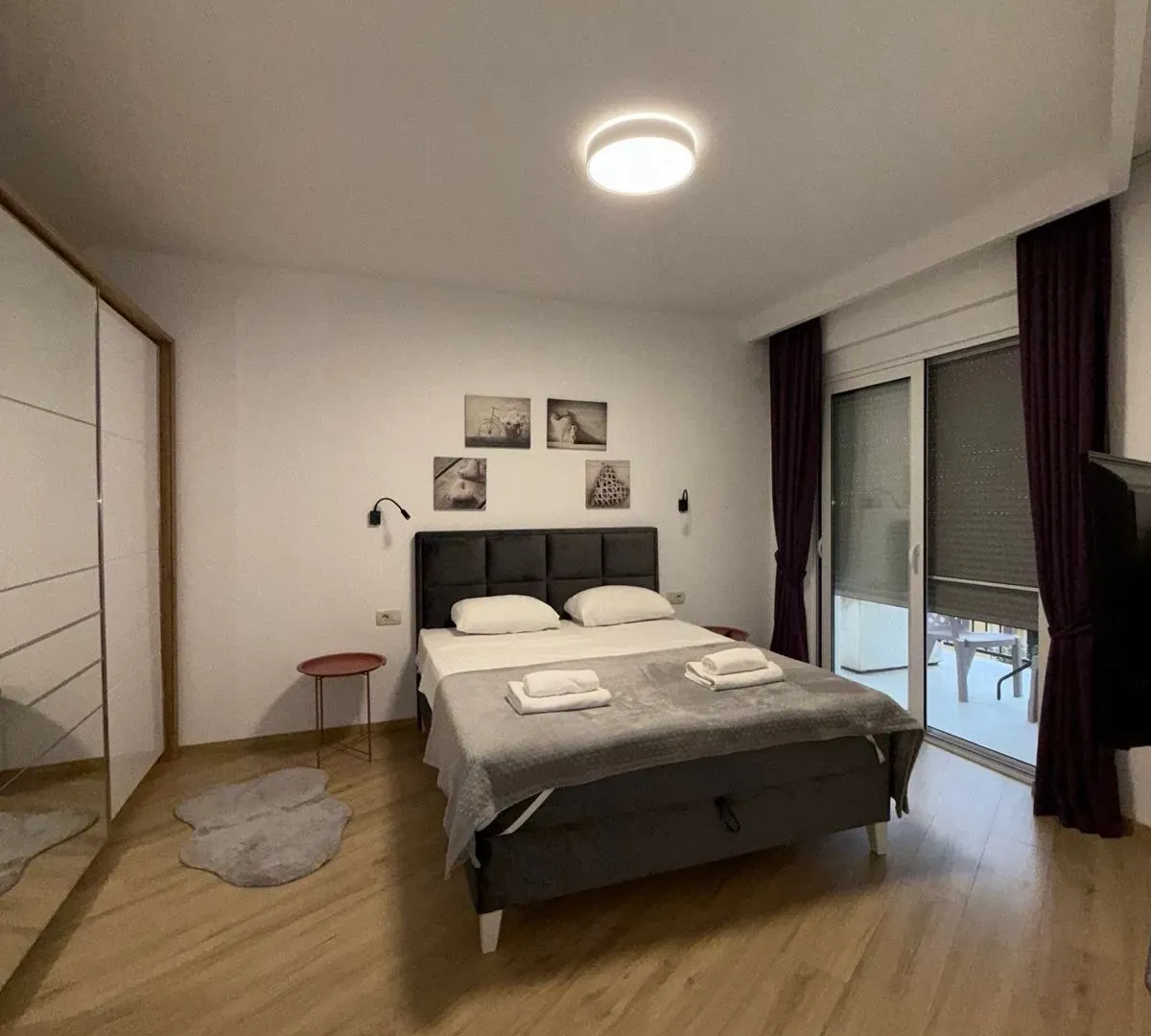 Furnished bedroom with a double bed, wardrobe, and balcony access.