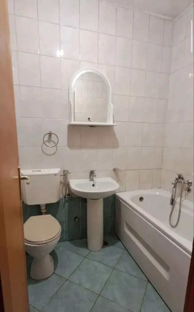 Kupatilo opremljeno kadom, umivaonikom, WC šoljom i ogledalom.