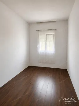 Prazna manja soba sa bijelim zidovima, tamnim laminatom i jednim prozorom. - image 9