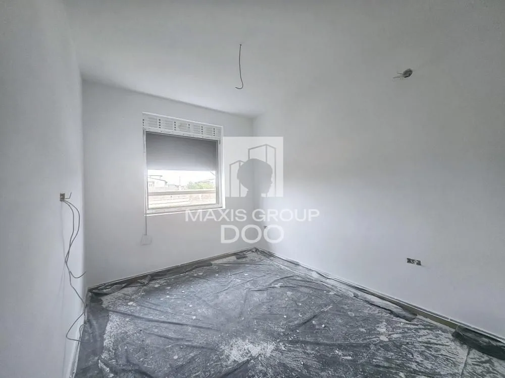 Empty unfinished room with white walls and a window.