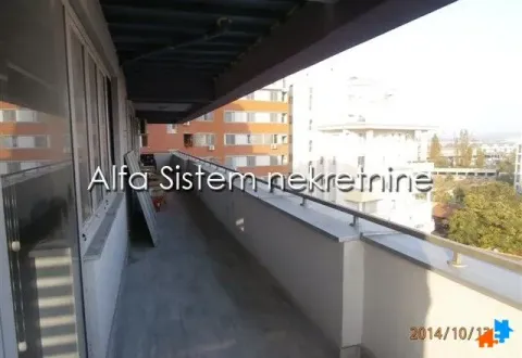 Dugačak natkriveni balkon sa pogledom na okolne zgrade. - image 22