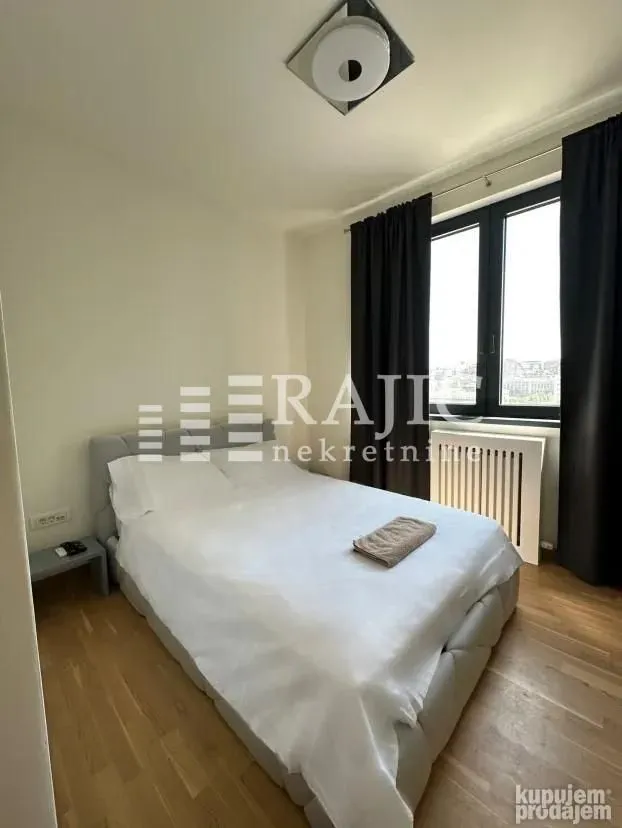 Furnished bedroom with a double bed and a window.