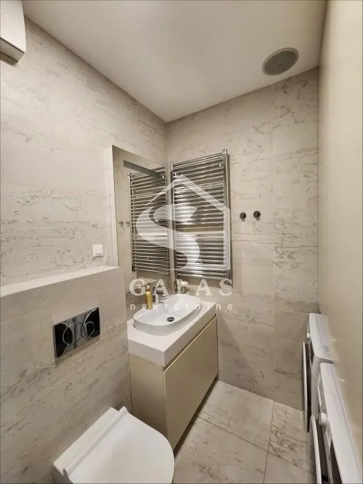 Modernly equipped bathroom with a washbasin, toilet, and washing machine.