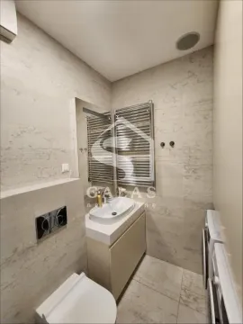 Modernly equipped bathroom with a washbasin, toilet, and washing machine. - image 9