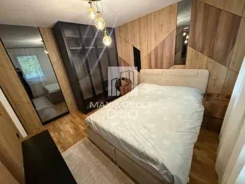 Furnished bedroom with a double bed, wardrobe, and wooden wall paneling. - image 12