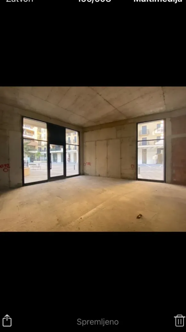 Unfinished commercial space in grey phase with large glass surfaces.