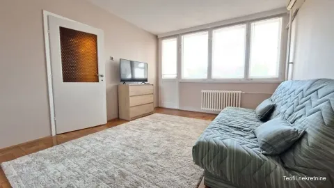 Living room with a sofa, chest of drawers, television, and large window. - image 4