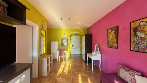 Dnevna soba sa šarenim zidovima, parketom i trpezarijskim delom u pozadini. - image 9