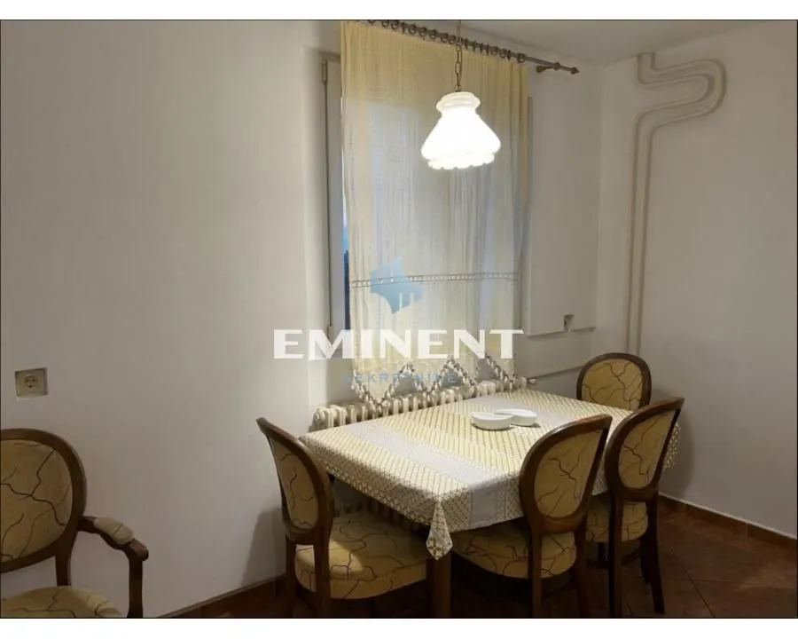 Dining area with a table, chairs, and a window.