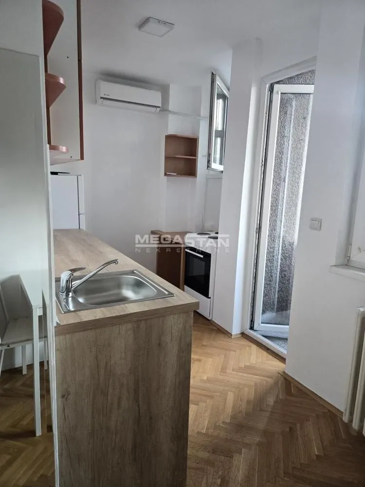 Small kitchen with a sink on the counter and access to the terrace.