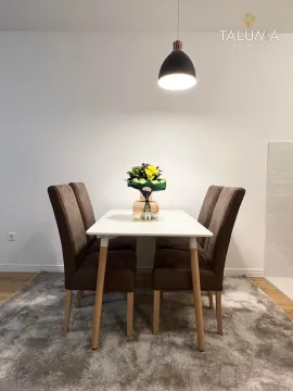Dining table with four chairs and a pendant light above. - image 4