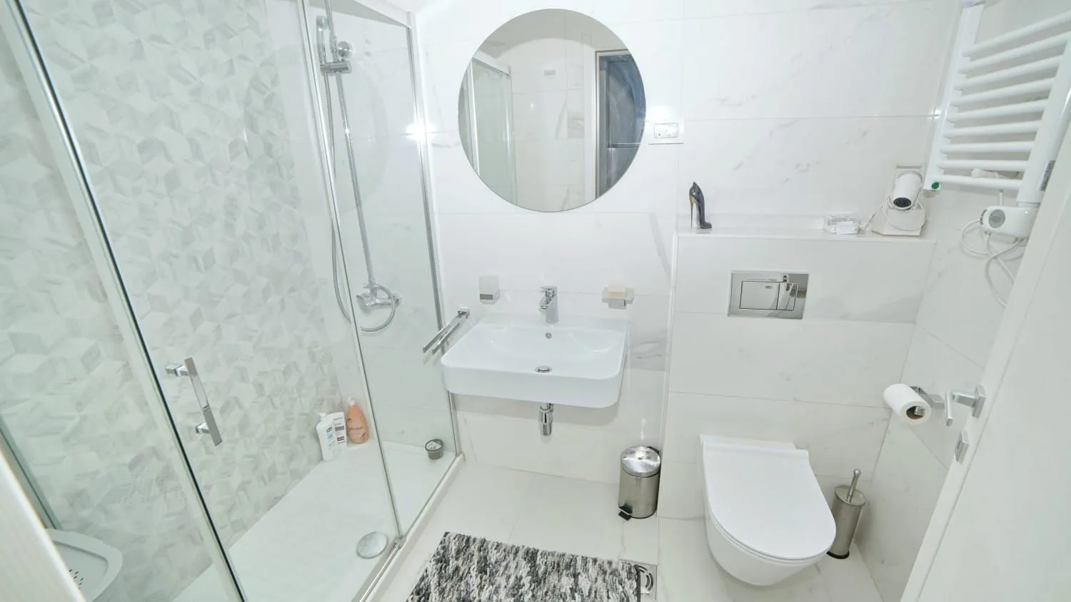 Modernly equipped bathroom with a shower cabin and white sanitary ware.