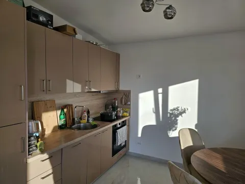 Kitchen with beige units and a dining table. - image 4