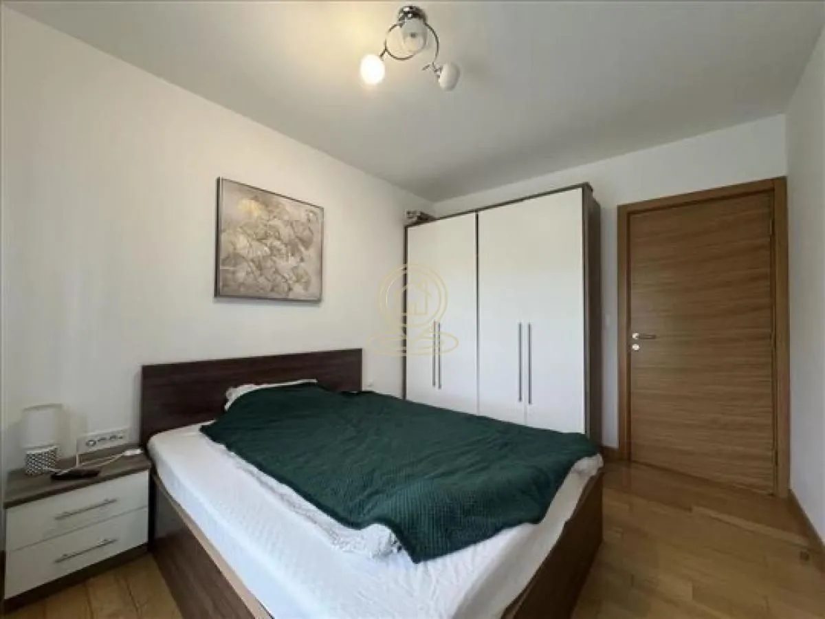 Furnished bedroom with a double bed, wardrobe, and wooden flooring.