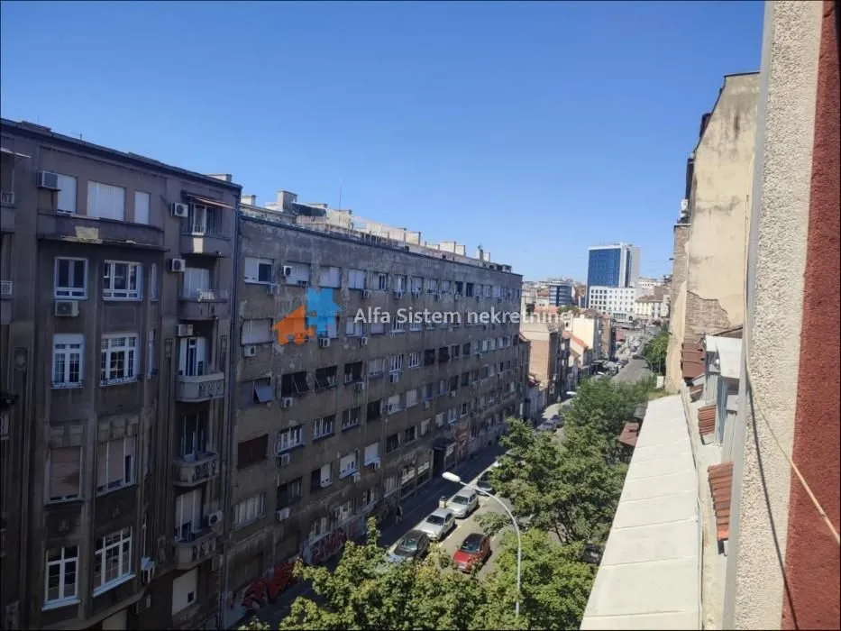 Pogled sa prozora na okolne zgrade i gradsku ulicu.