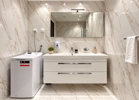 Modern bathroom equipped with a washbasin, a large mirror, and a washing machine. - image 9