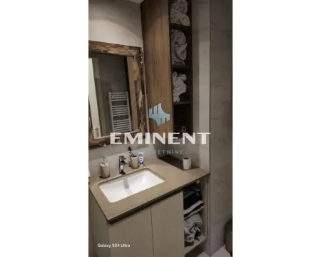 Bathroom with a sink, mirror, and wooden cabinet for towels. - image 11