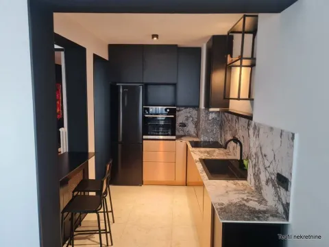 Modern kitchen with black units and a marble countertop. - image 5