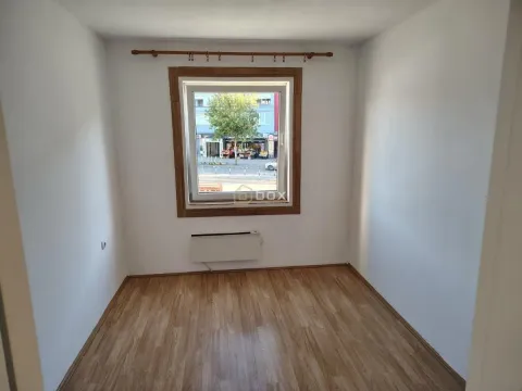 Empty room with laminate flooring and a window overlooking the street. - image 8