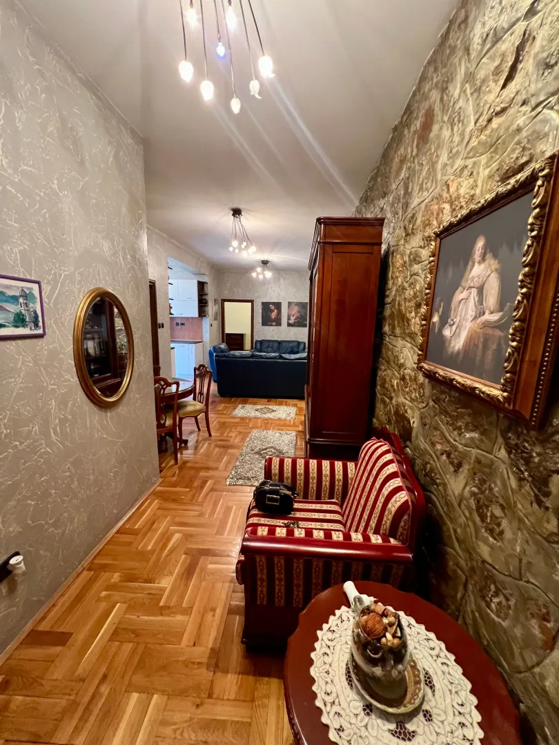 Living room with parquet flooring and a stone wall.