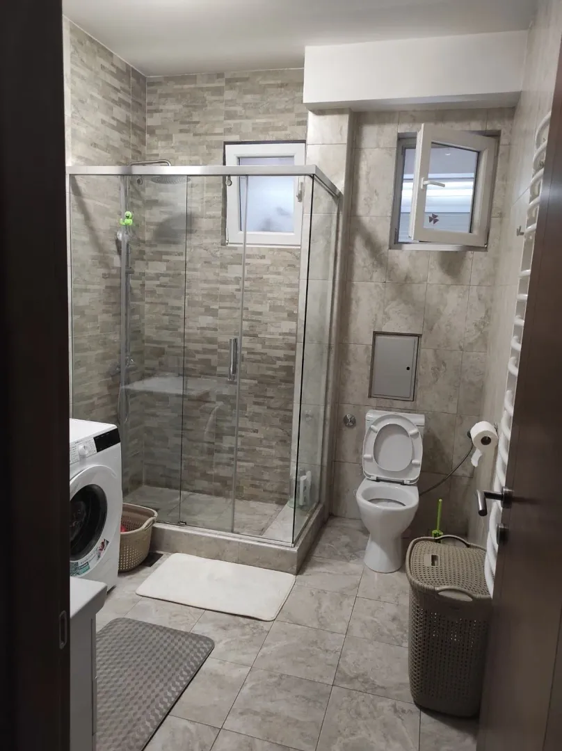 Bathroom with a shower cabin and washing machine.