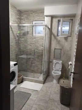 Bathroom with a shower cabin and washing machine. - image 5