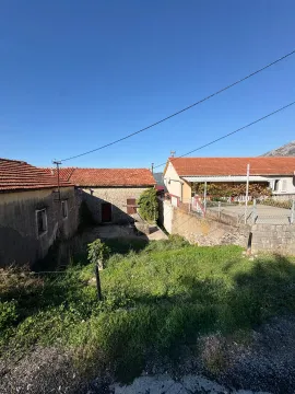 Pogled na stare kamene kuće sa dvorištem i travnjakom. - image 2