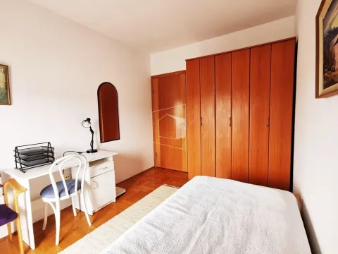 Bright bedroom with a desk and a large wooden wardrobe. - image 14