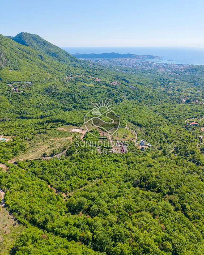 Pogled iz vazduha na zeleni predio i brda u okolini.