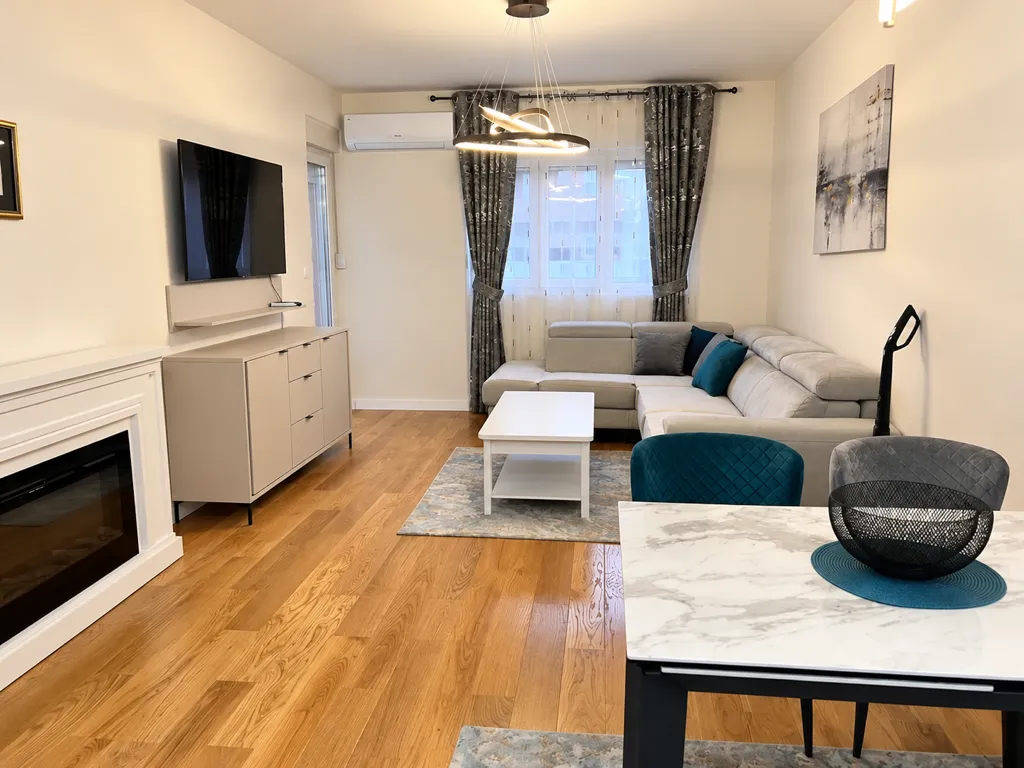 Spacious living room with a sectional sofa, TV, and dining table.