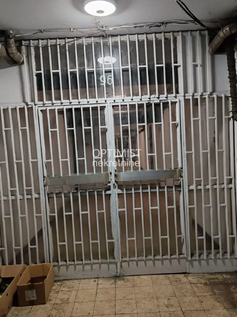 Entrance door with protective grilles and cardboard boxes on the floor.