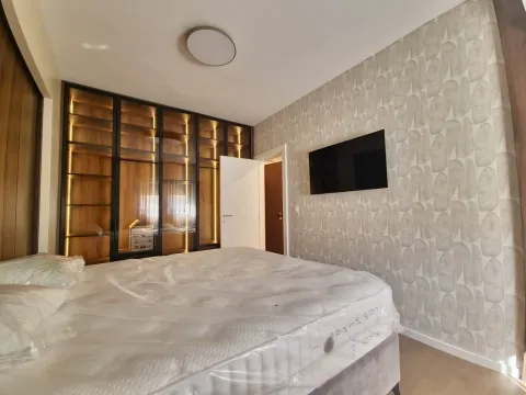 Bedroom with a large bed and a built-in wardrobe with lighting. - image 4