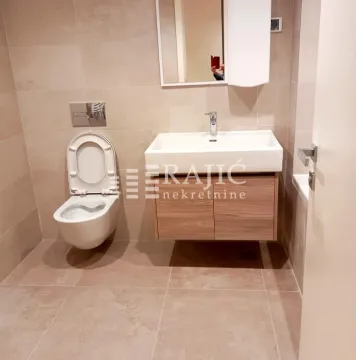 Modernly equipped bathroom with sanitary ware and a sink. - image 10