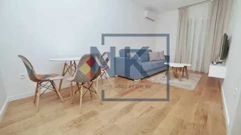 Dnevna soba sa garniturom za sjedenje, trpezarijskim stolom i drvenim podom. - image 2