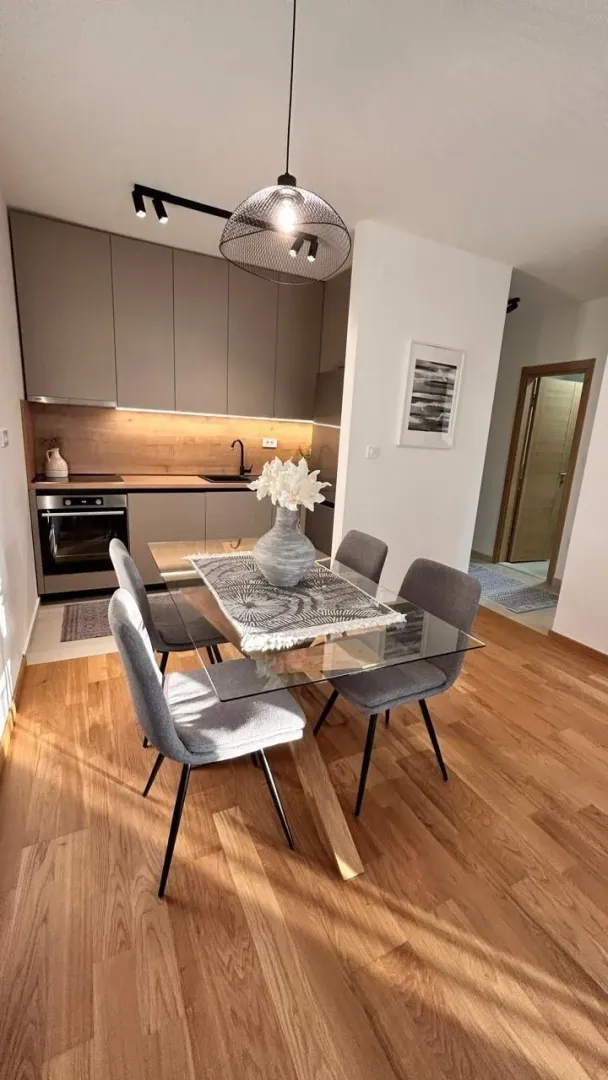 Modern kitchen featuring a light wooden floor and a dining table.