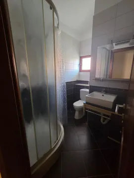 A simple bathroom with a shower cabin, sink, and toilet. - image 9