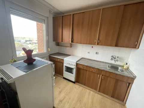 Kitchen with wooden cabinetry, stove, sink, and refrigerator by the window. - image 4