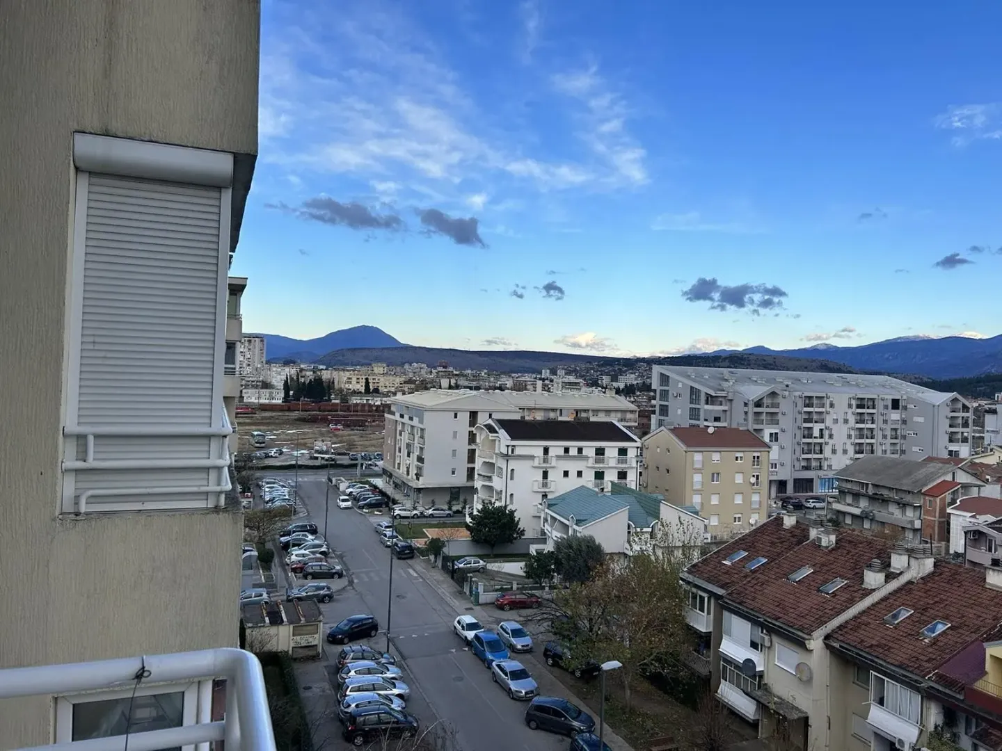 Pogled sa terase na gradsko naselje i planine u daljini.