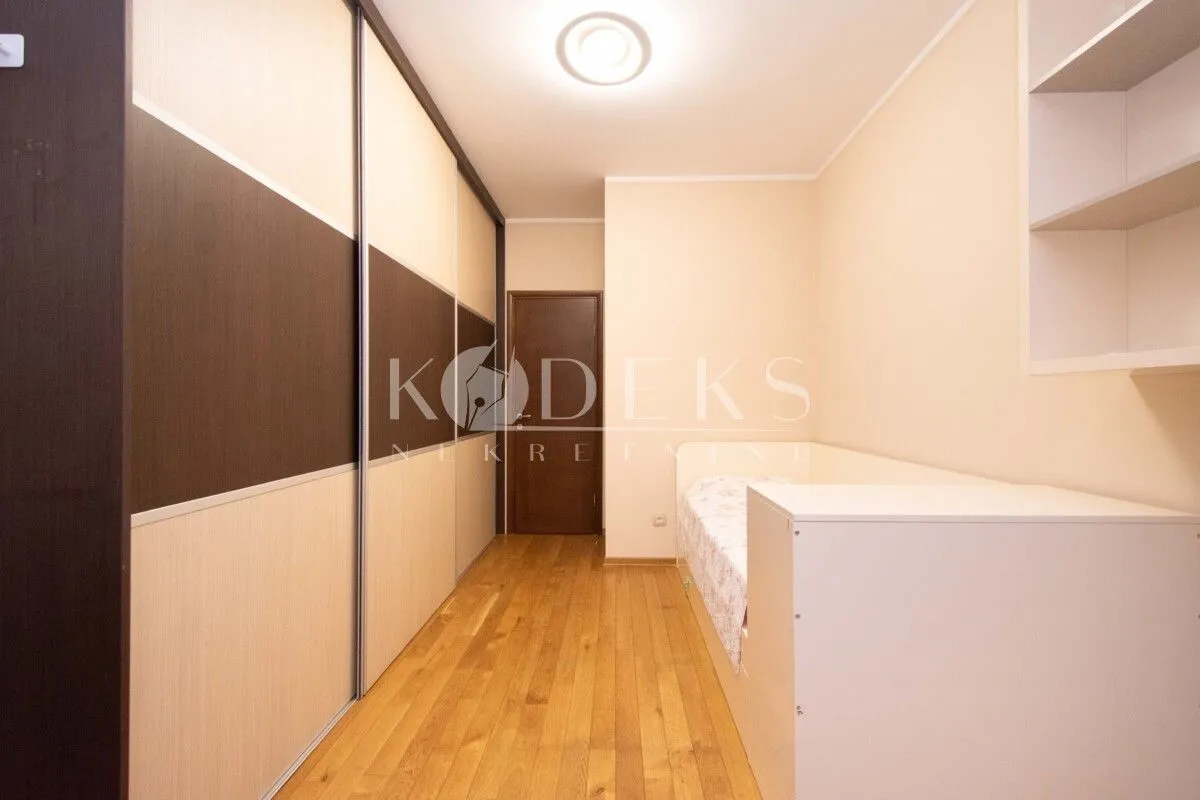 Smaller bedroom with a large built-in wardrobe and a bed.