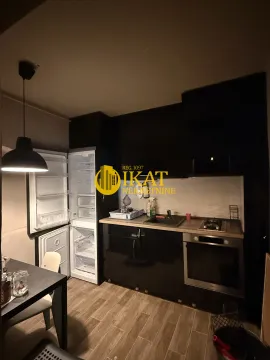 Small kitchen with black cabinets and built-in refrigerator and oven. - image 13
