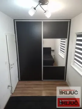 Spavaća soba sa velikim ugradnim garderoberom i krevetom. - image 4